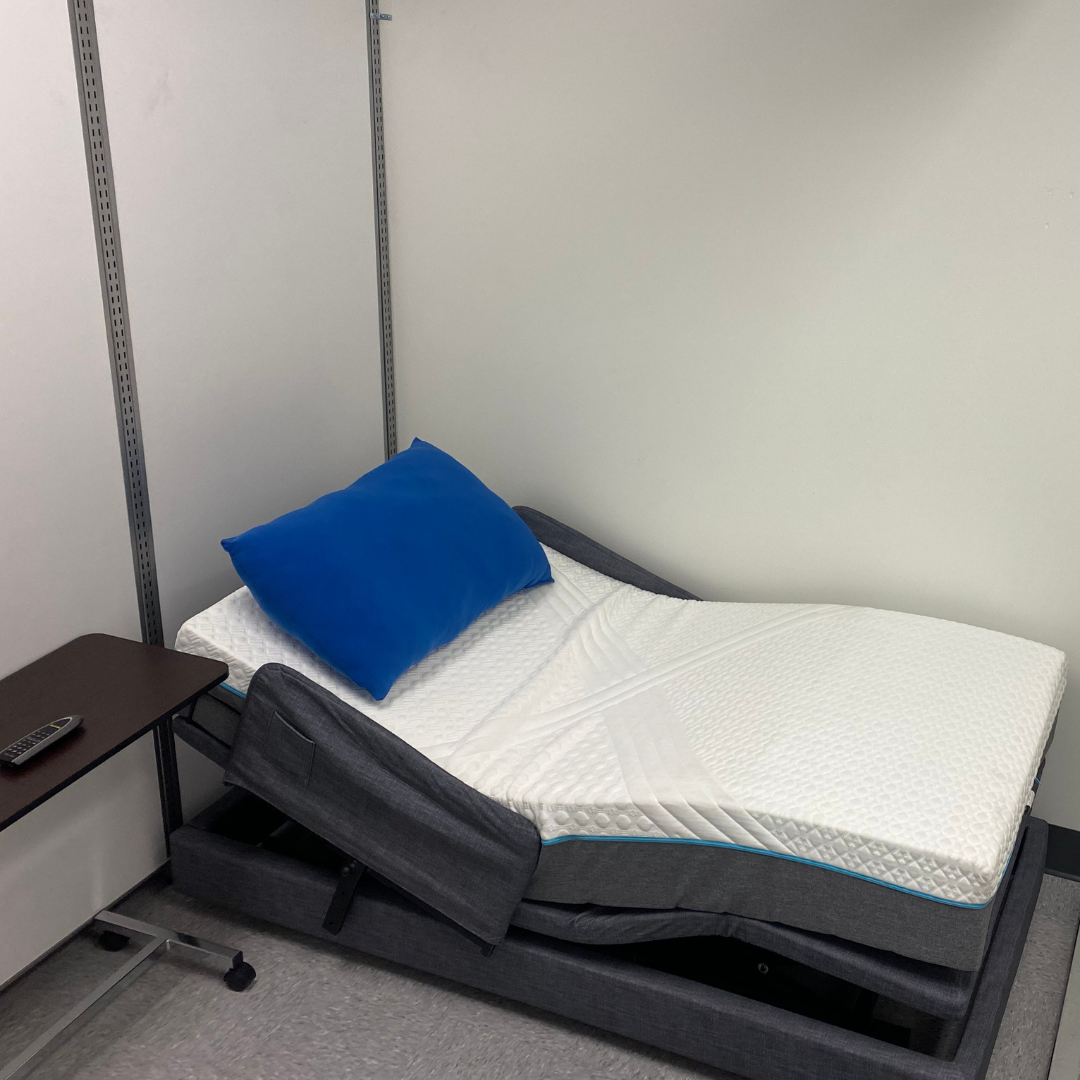 Assessment room with adjustable bed and over-the-bed table